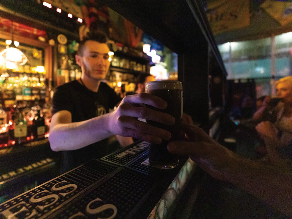 Bartender handing a Guinness to a patron