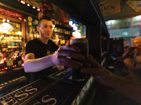 Bartender handing a Guinness to a patron