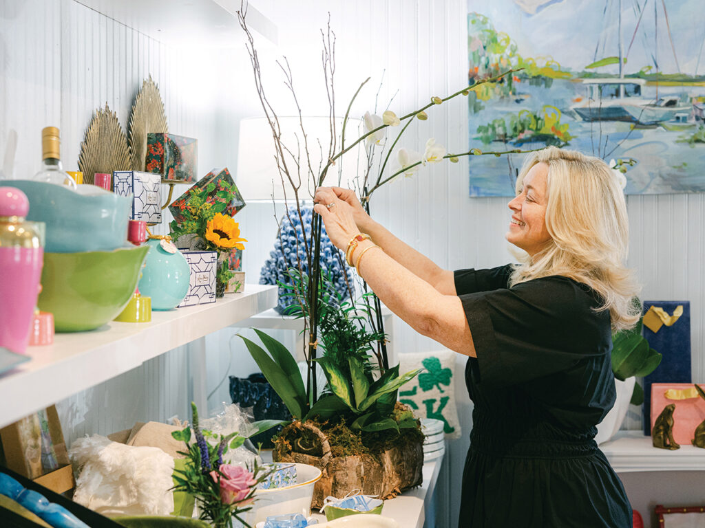 Woman smiling and tending to an orchid