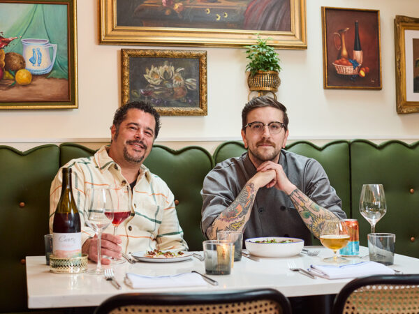 Two men sitting at a table and drinking wine