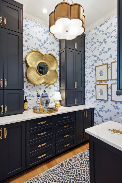 Butler's pantry with dark blue cabinetry and patterned wallpaper