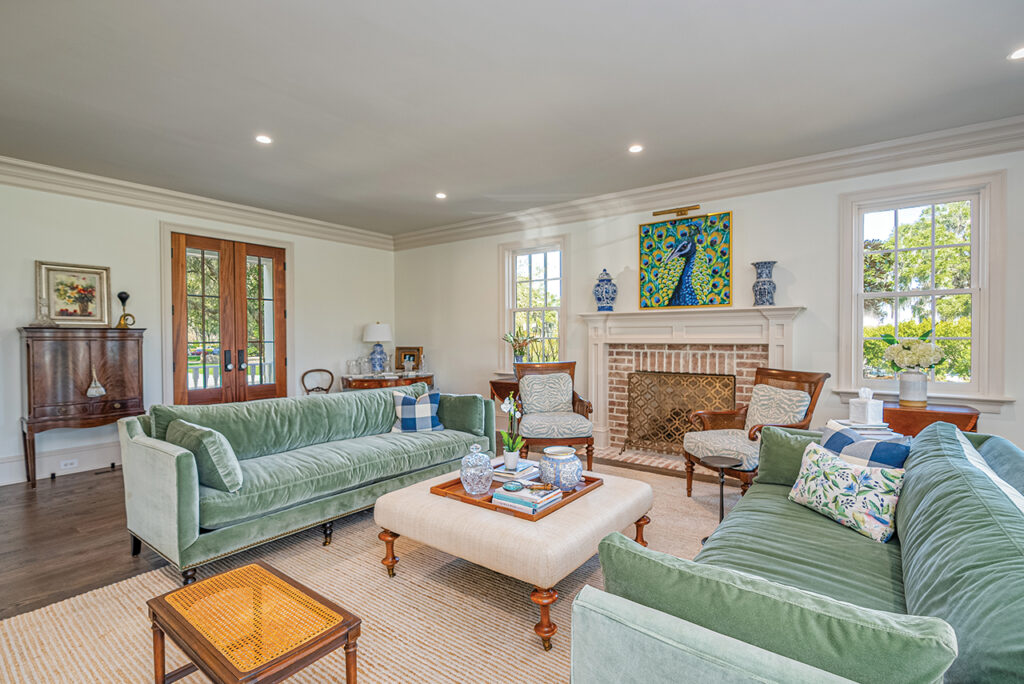 Living room with antiques and two light green couches