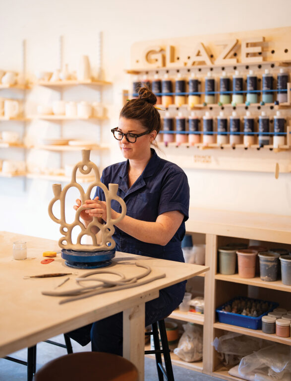 Woman creating a candelabra in a pottery studio