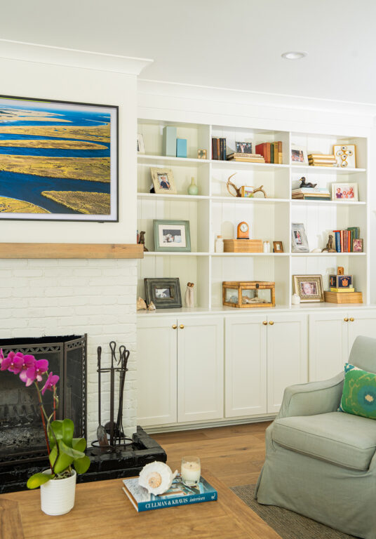 built-in bookshelves next to a white brick fireplace in a living room