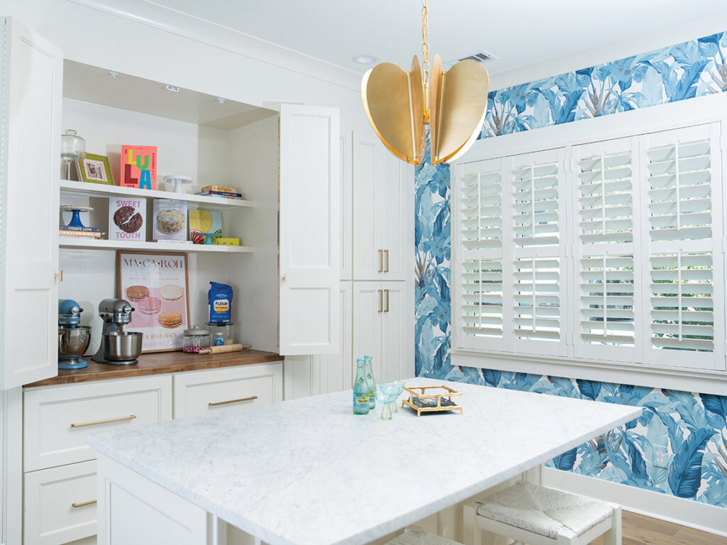 kitchen with white cabinets and island and wallpaper with blue leaves
