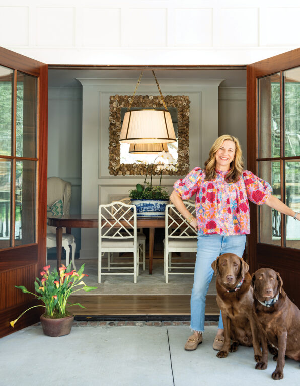 Woman standing in doorway with two chocolate Labrador retrievers