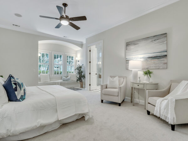 Neutral colored primary bedroom with seating area