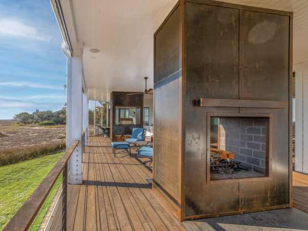 Back patio overlooking the marsh, with a metal-encased fireplace and smoker