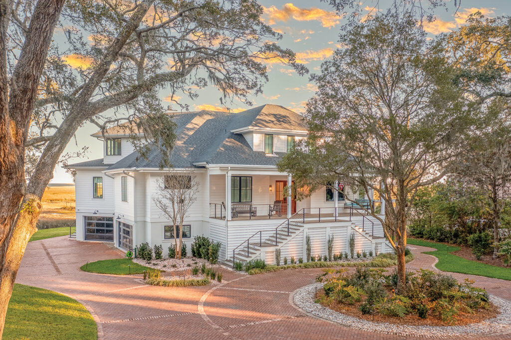 Exterior of a white Southern style marshside home with brick driveway