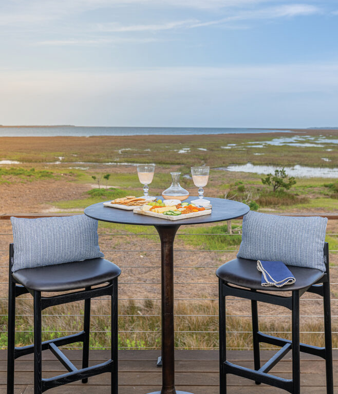 Bar height stools and round table with charcuterie board and wine