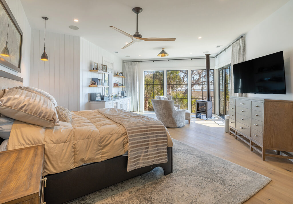 Primary bedroom with wood burning stove, seating area, and wet bar