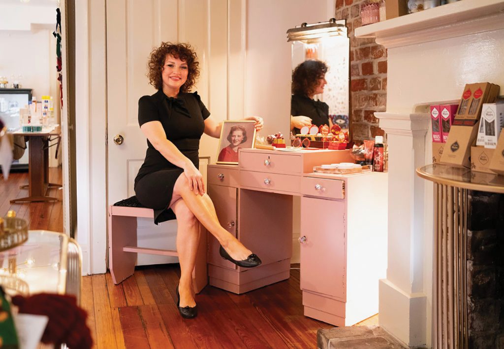 Woman sitting in front of makeup mirror