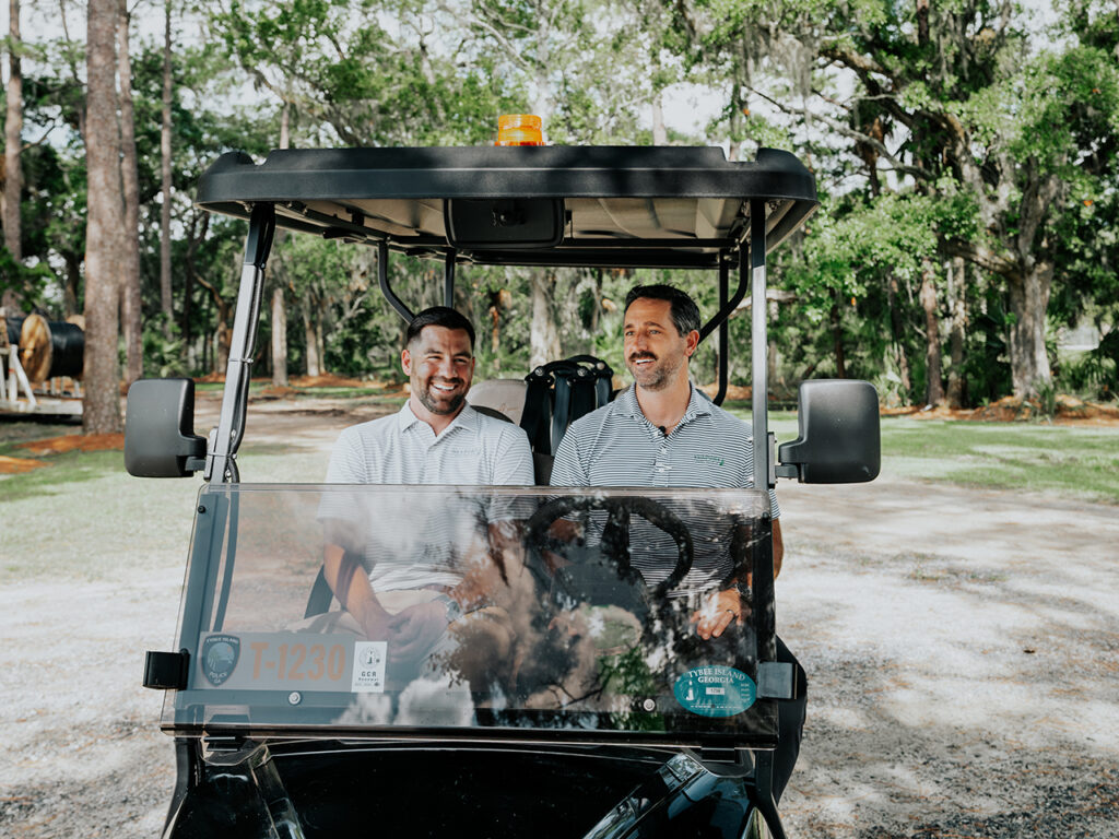 Two real estate agents riding in a golf cart on Dutch Island