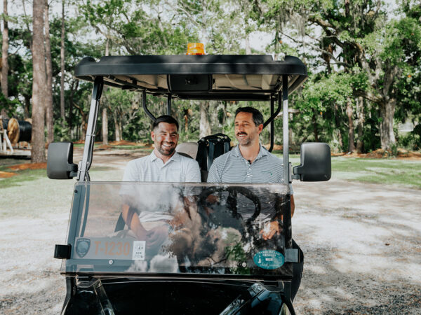 Two real estate agents riding in a golf cart on Dutch Island
