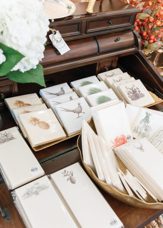 A display of specialty napkins with printed designs of pineapples, pheasants, and palm trees