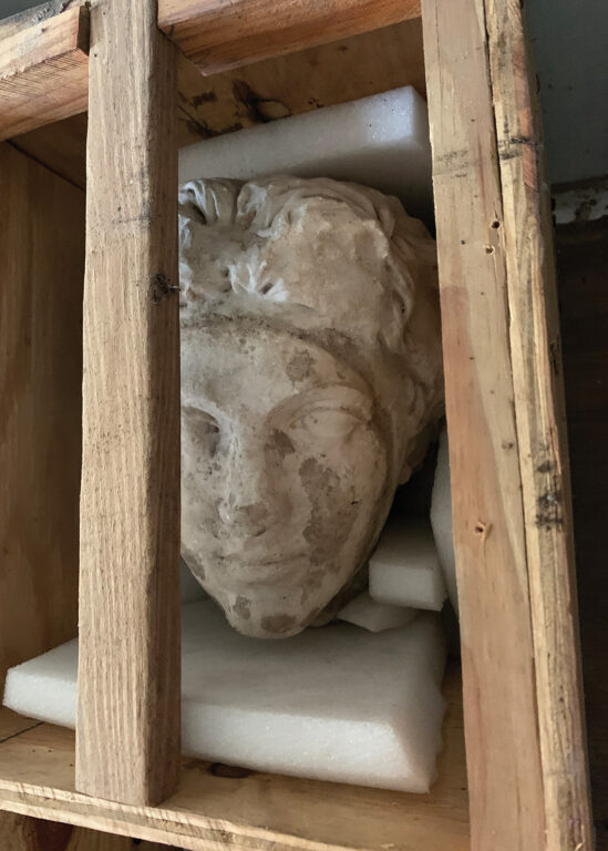 a statue head in a storage crate