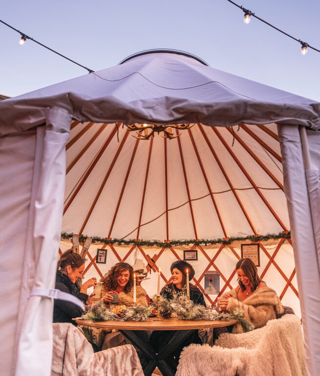 friends eating and drinking in a yurt