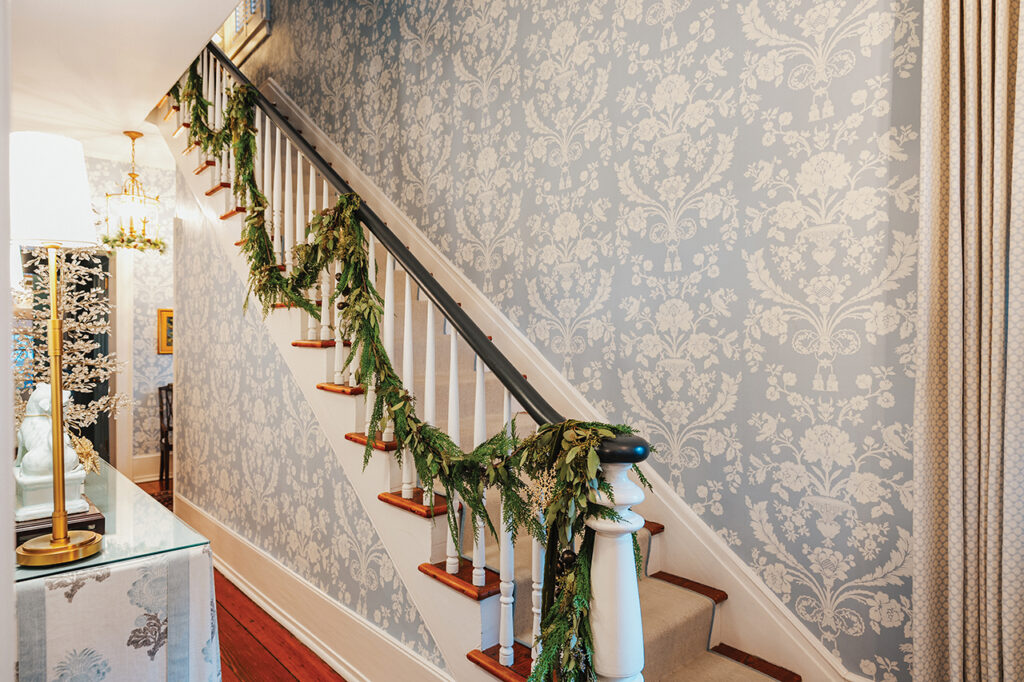 The handrail of a staircase decorated with holiday greenery
