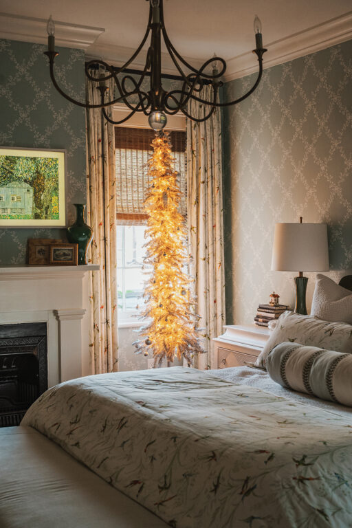 A tall, skinny Christmas tree in a bedroom
