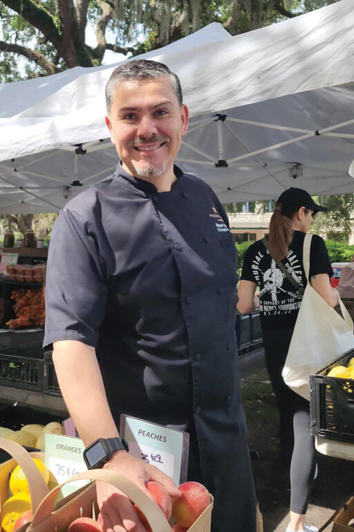 Chef Miguel Bautista from The Emporium Kitchen and Wine Market shops at the Forsyth Farmers' Market in Savannah, Georgia.
