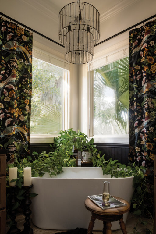 soaking tub in a bathroom with dark bird-patterned curtains