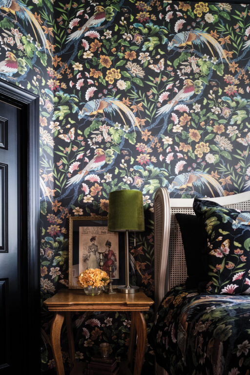 bedroom with dark bird-patterned wallpaper and bedding