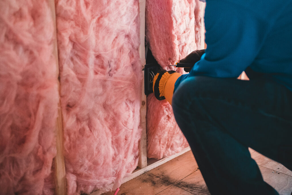 man installing insulation in walls