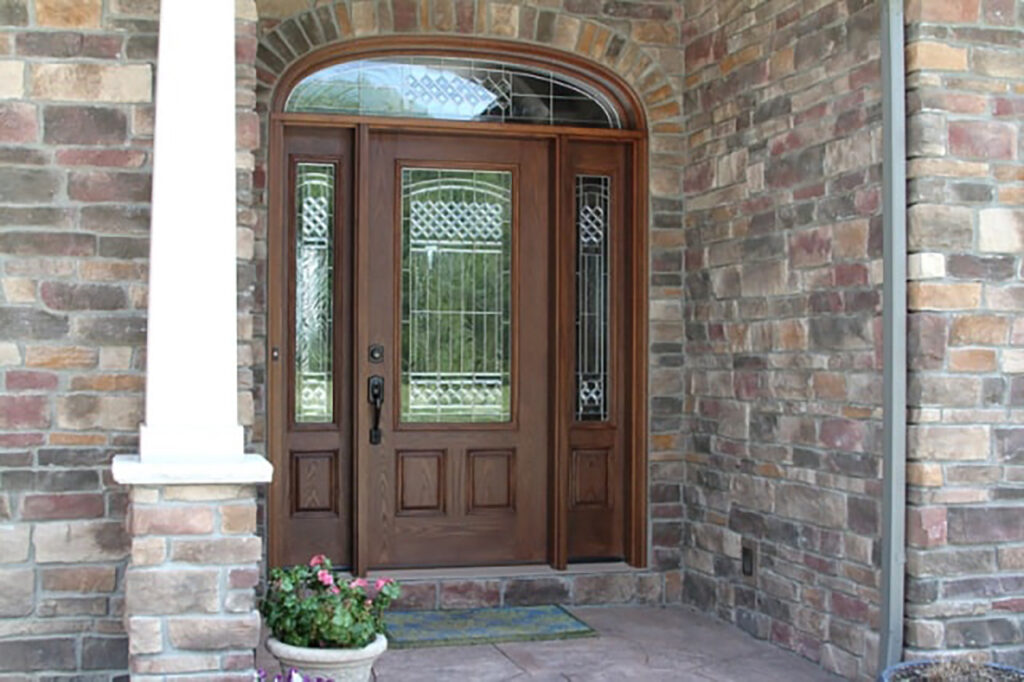 fiberglass wood-look door to a brick home