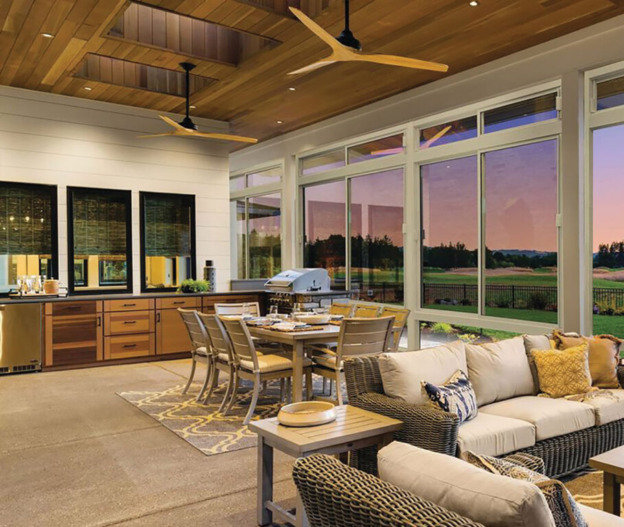 An enclosed patio with dining area and kitchen by Coastal Canvas products