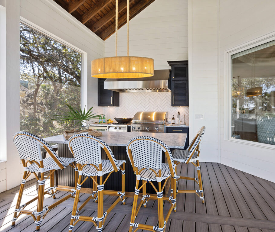 An outdoor kitchen with an island by Kitchen Design Solutions