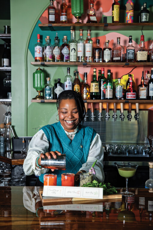woman mixing drinks behind a bar
