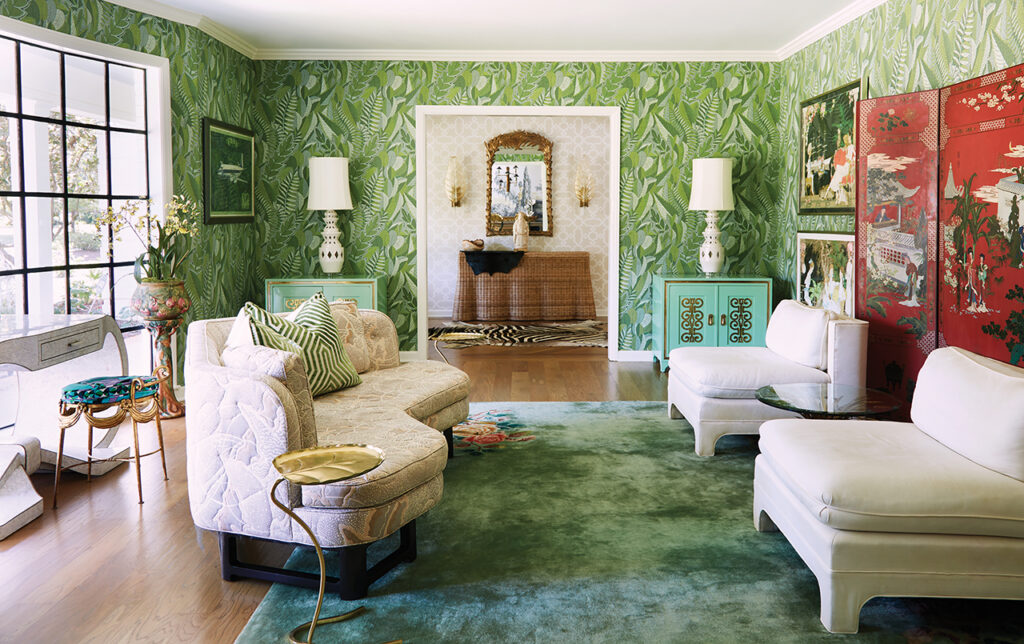 Living room with Schumacher Japura Forest palm leaf wallpaper, a red Japanese wall screen, and a Chinese Art Deco rug