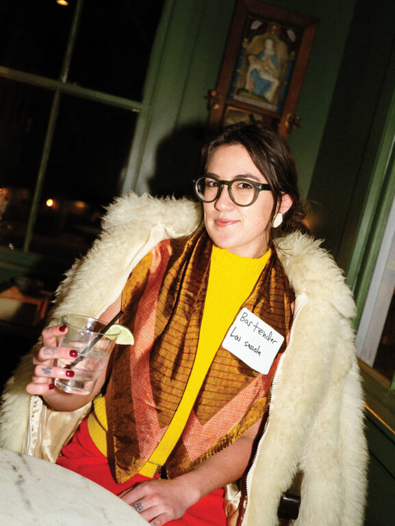 Woman in a white fur coat holding a cocktail