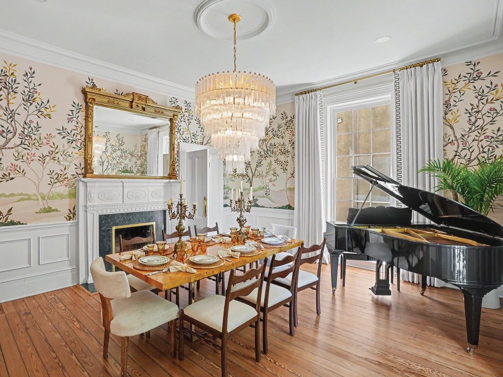 Dining room with crystal chandelier, baby grand piano, wood floors, and hand-painted murals